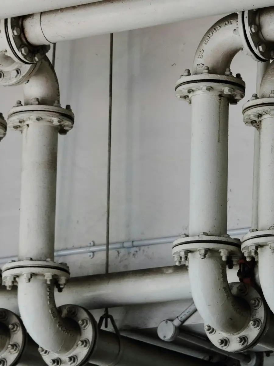 Flanged steel pipework running through a commercial plant room